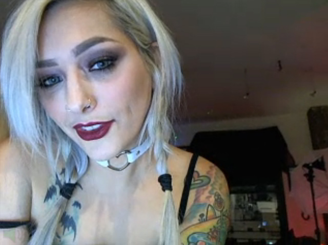 Sexy inked cam girl covered in tattoos, pierced nipples, live on webcam teasing.